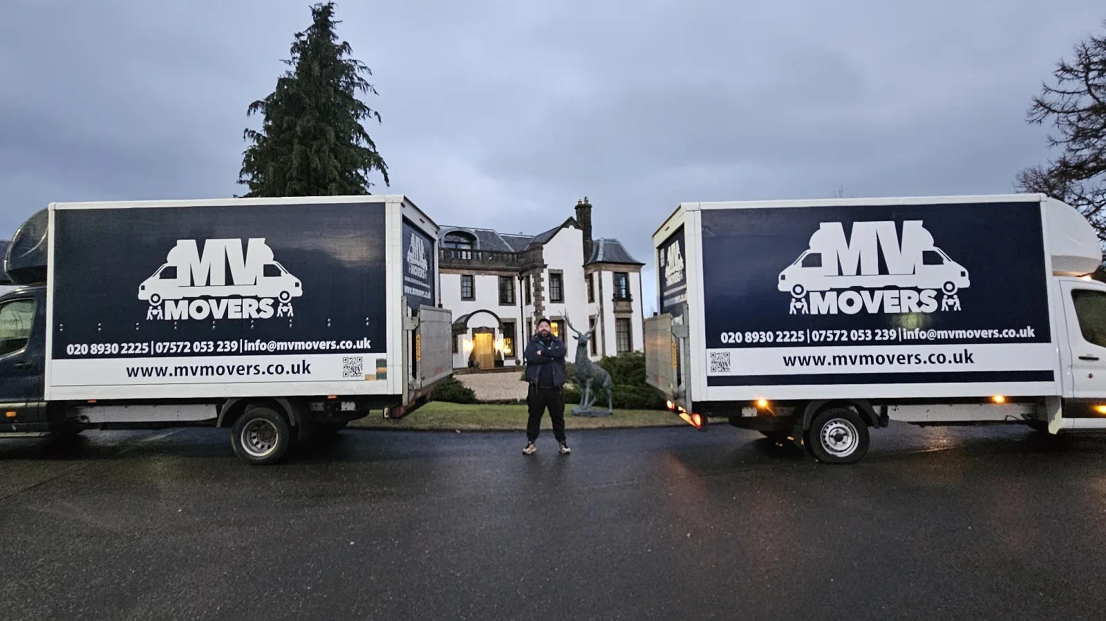 Two branded MV Movers vans outside a customer home